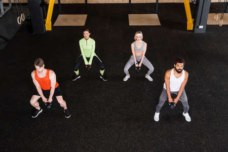 high angle view of interracial sports people working out with kettlebells
