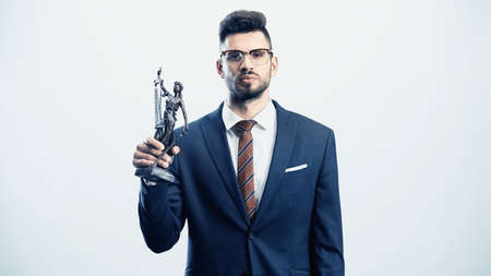 confident businessman with justice statuette looking at camera isolated on whiteの写真素材