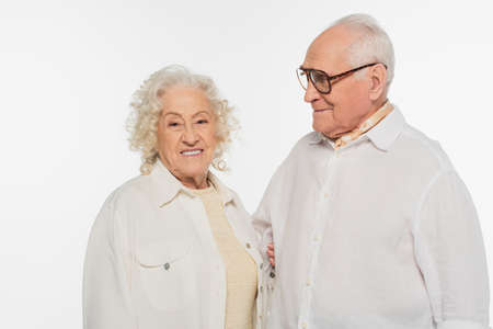 smiling elderly couple in casual clothes standing together isolated on whiteの写真素材