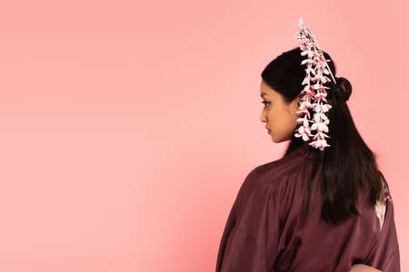 Side view of japanese woman with traditional kanzashi in hair isolated on pinkの写真素材
