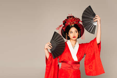 Japanese woman in oriental clothes holding fans isolated on grayの写真素材