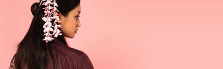 Side view of young asian woman with hairsick looking away isolated on pink, bannerの写真素材