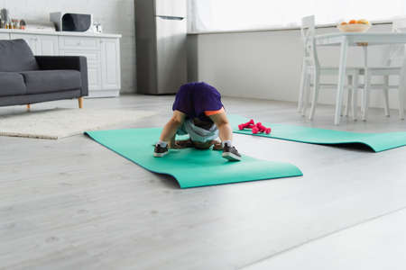 Asian kid having fun on fitness mat at homeの写真素材