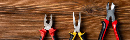 top view of pliers and wire cutters on wooden surface, labor day concept, bannerの写真素材