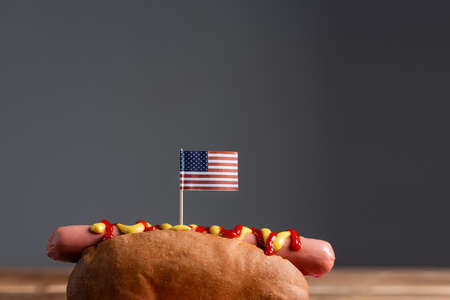 tasty hot dog with small american flag isolated on gray with copy spaceの写真素材