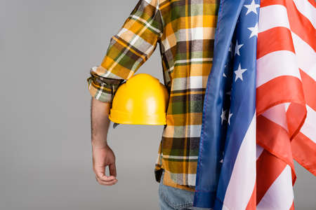 back view of cropped workman with hardhat and usa flag isolated on gray, labor day conceptの写真素材