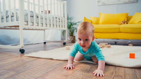 infant boy crawling on floor in living roomの写真素材