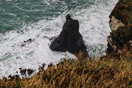 high angle view of rocky coastline and sea waves with foam
