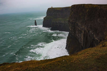 scenic view of rocky coastline and sea waves with foam