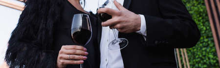 partial view of couple holding glasses of red wine, bannerの写真素材