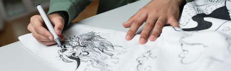 partial view of artist drawing on kimono in fashion atelier, bannerの写真素材