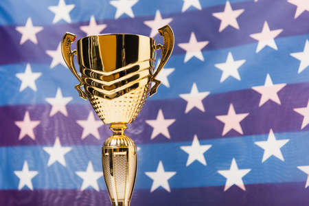 golden cup with stars of american flag on blurred backgroundの写真素材