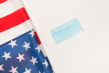 top view of american flag near medical mask isolated on whiteの写真素材