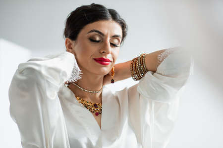 indian bride with closed eyes wearing necklace on whiteの写真素材