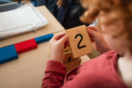 cropped view of blurred boy holding wooden card with number twoの写真素材