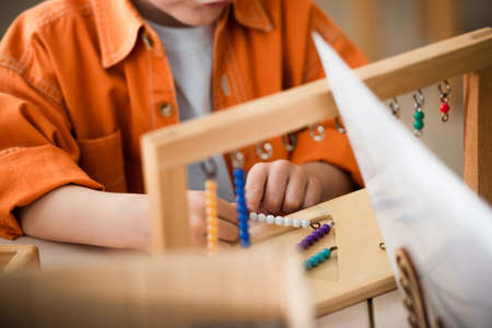 partial view of kid playing colorful beads game on blurred foregroundの写真素材