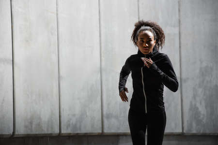 African american woman running near buildingの写真素材