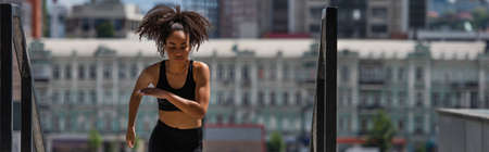 Young african american runner training near railing, bannerの写真素材