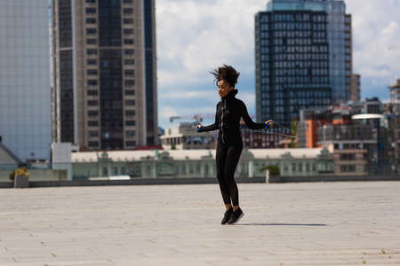 African american sportswoman exercising with skipping rope on urban streetの写真素材
