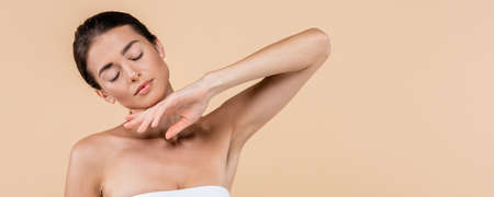 sensual woman with closed eyes holding hand near chin isolated on beige, beauty concept, bannerの写真素材