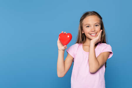Happy kid with decorative heart isolated on blueの写真素材