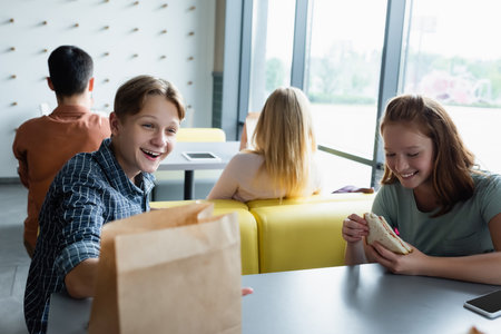 teenage pupils smiling during lunch break in school eateryの写真素材