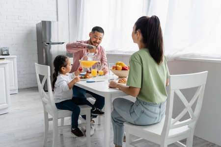 happy asian family having breakfast in kitchenの写真素材