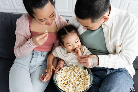top view of happy asian family eating popcorn in living roomの写真素材