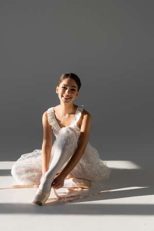 Young ballerina wearing pointe shoes on gray backgroundの写真素材