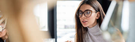 brunette businesswoman in eyeglasses in office on blurred foreground, bannerの写真素材