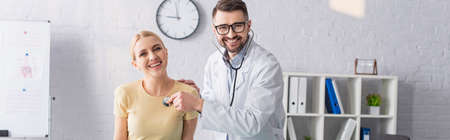 happy doctor and patient looking at camera during diagnostics in clinic, bannerの写真素材