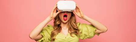 shocked woman in vr headset isolated on pink, bannerの写真素材