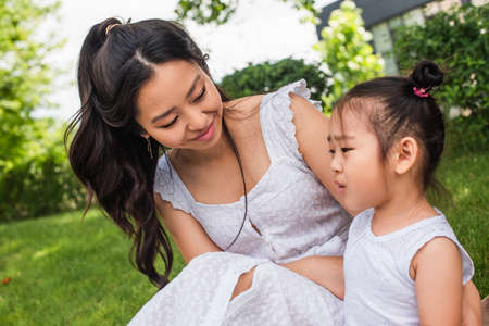 happy young asian mother looking at toddler daughter outsideの写真素材