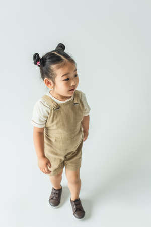 high angle view of asian toddler girl posing on grayの写真素材