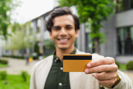 happy and blurred man holding credit card outsideの写真素材