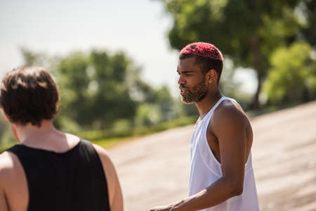 African american sportsman talking near blurred friend outdoorsの写真素材