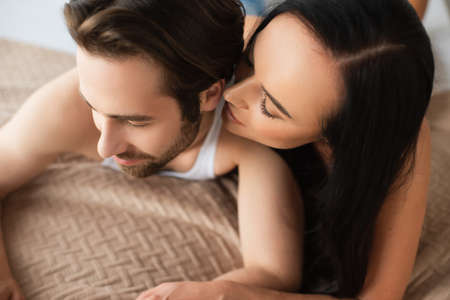 high angle view of young couple lying in bed