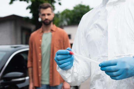 Medical worker in latex gloves holding pcr test near blurred driverの写真素材