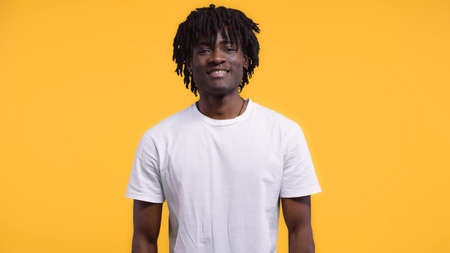 smiling happy african american man with dreadlocks isolated on yellow
