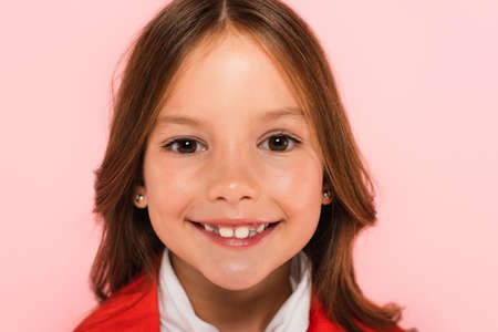 portrait of happy girl looking at camera isolated on pink