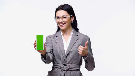 Smiling businesswoman holding smartphone with blank screen and showing like isolated on whiteの写真素材