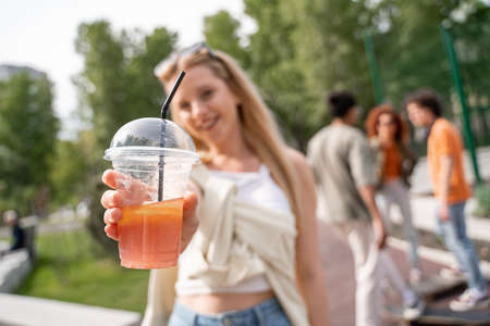 selective focus of fresh cocktail in hand of blurred womanの写真素材