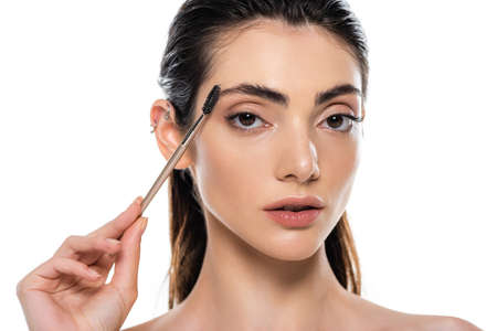 young woman styling eyebrow isolated on whiteの写真素材