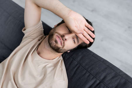 High angle view of sick man suffering from headache