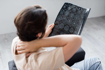 Blurred man holding mri san at home