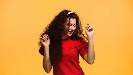 happy woman in red blouse dancing isolated on orange