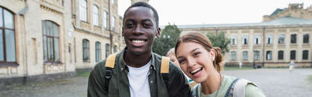 Smiling interracial students looking at camera outdoors, bannerの写真素材