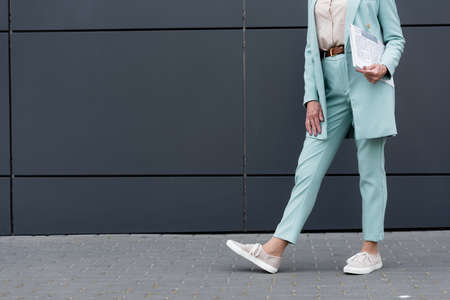 Cropped view of senior businesswoman holding newspaper outdoorsの写真素材