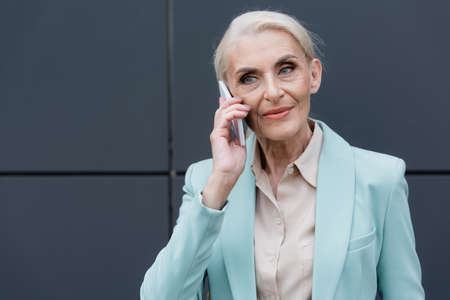 Elderly businesswoman talking on smartphone outdoors