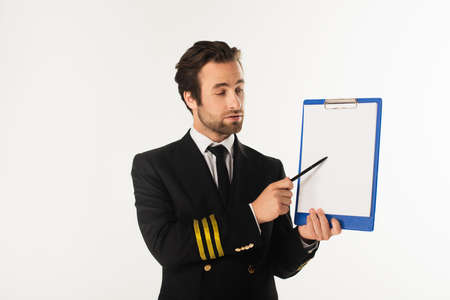 Young pilot pointing at clipboard isolated on whiteの写真素材
